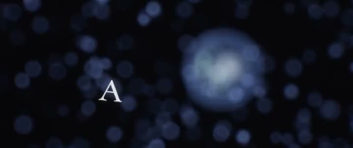 Video scene of the letter A rising among blue orbs of light on a dark background